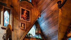 A wooden interior with a red door, a staircase, and a chair. - The Wizard's Retreat near Top Attractions! (Sevierville)