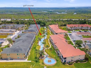 A golf course with a pool and resort buildings.