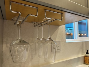 A kitchen with a wine rack holding several wine glasses.