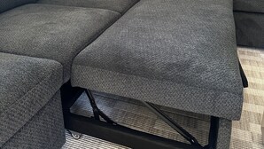 A sectional sofa with a dark fabric, two pillows, and a black metal frame. - New Cozy Modern Cottage with Hot Tub & Fire Pit! (Ponderay)