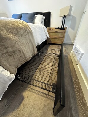 A bedroom with a bed, a nightstand, a lamp, and a radiator. - New Cozy Modern Cottage with Hot Tub & Fire Pit! (Ponderay)