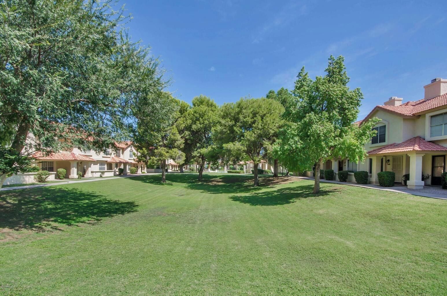 Un quartier résidentiel avec des maisons, des pelouses bien entretenues et des arbres.
