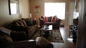 Ein Wohnzimmer mit zwei Sofas, einem Couchtisch und einer Schildkröte auf dem Boden.