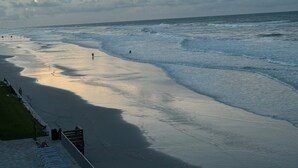 Une plage avec une promenade et des chaises disposées le long du rivage.