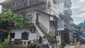 A multi-story building with balconies, a staircase, and a signboard. - Vangvieng Victory Hostel (Vang Vieng)