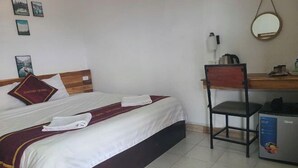 A hotel room with a bed, a desk, a chair, and a refrigerator. - Vangvieng Victory Hostel (Vang Vieng)