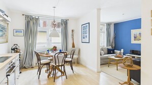 A modern apartment with a dining area, kitchen, and living space. - Cozy vacation apartment "Inselglück" - roof terrace, lake view, central (Lindau)