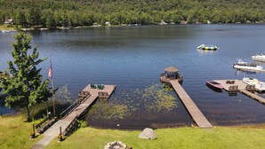 A lakeside dock with boats, a gazebo, and a flagpole. - Grace - Big Moose Lakeside (Eagle Bay)
