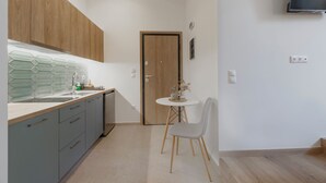Una cocina moderna con un mueble de madera, un lavamanos y una zona de comedor con mesa y sillas.