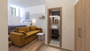 Un dormitorio moderno con cama, sofá, una mesita y un armario.