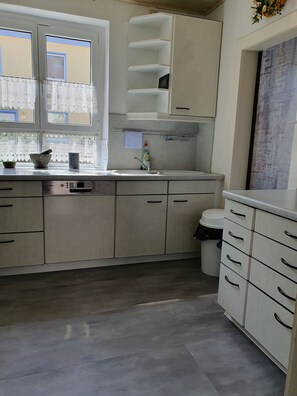 Una cocina con lavavajillas Bosch, un lavabo y un cubo de basura.