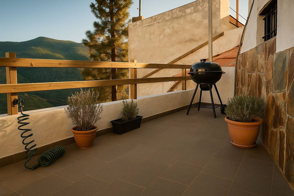 A balcony with a wooden railing, a barbecue grill, and potted plants.