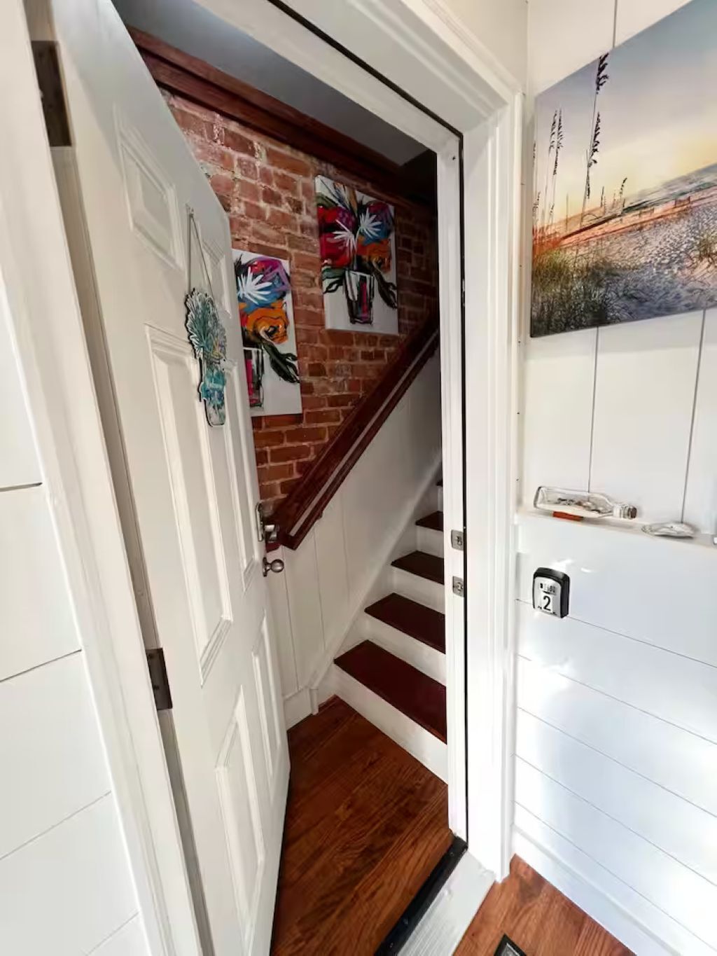 Een trap met een bakstenen muur en een deur met een decoratief bord.