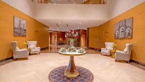 A spacious lobby with a central round table, two armchairs, and a vase of flowers. - Park Inn By Radisson Lucknow Vikas Nagar (Lucknow)
