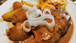 A plate of food with meat, potatoes, and a creamy sauce. - Hotel Restaurant Ampertal (Haag an der Amper)