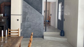 A modern interior with a dining area, a staircase, and a view into another room. - Landsberg artist farmhouse - Unique (Pürgen)