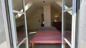 A bedroom with a bed, a nightstand, and a lamp. - Landsberg artist farmhouse - Unique (Pürgen)