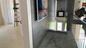 A modern interior with a concrete wall, a framed picture, a staircase, and a metal railing. - Landsberg artist farmhouse - Unique (Pürgen)