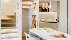 Une cuisine moderne dotée d’un îlot central, de chaises en bois et d’un coin repas avec un canapé.