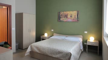 Una camera da letto con un letto, due comodini con lampade, un armadio e un quadro appeso al muro.