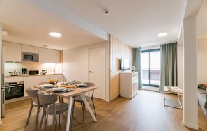 Un apartamento moderno con comedor, kitchenette y balcón con vistas.