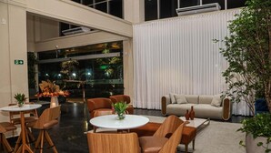A spacious lobby with a modern design, featuring a seating area with round tables and chairs, a sofa, and a large potted plant. - Amazon Park Hotel (Belém)