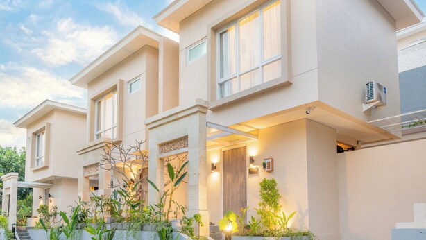 A modern two-story house with a flat roof, large windows, and a well-lit entrance. - Azura Villas Nusa Dua Bali (Nusa Dua)