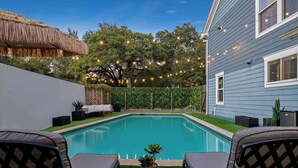 A backyard with a swimming pool, outdoor furniture, and string lights. - Poolside Funhouse with Arcade, Billiard, Poker (Austin)