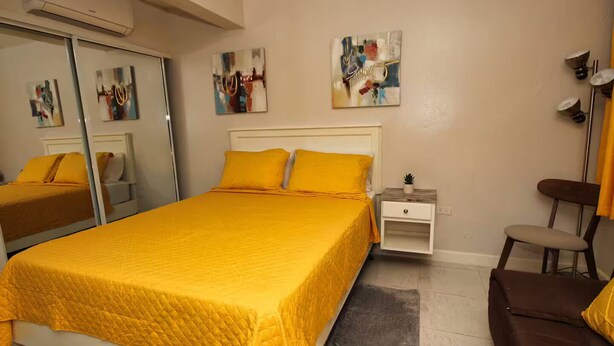 A bedroom with a bed, bedside table, chair, and artwork on the walls. - The Castle ᴶ (Philipsburg)