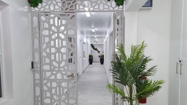 A hallway with a decorative gate, potted plants, and a fire extinguisher. - The Castle ᴵ (Philipsburg)