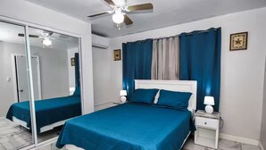 A bedroom with a bed, nightstands, a ceiling fan, and a mirror. - The Castle ᴵ (Philipsburg)