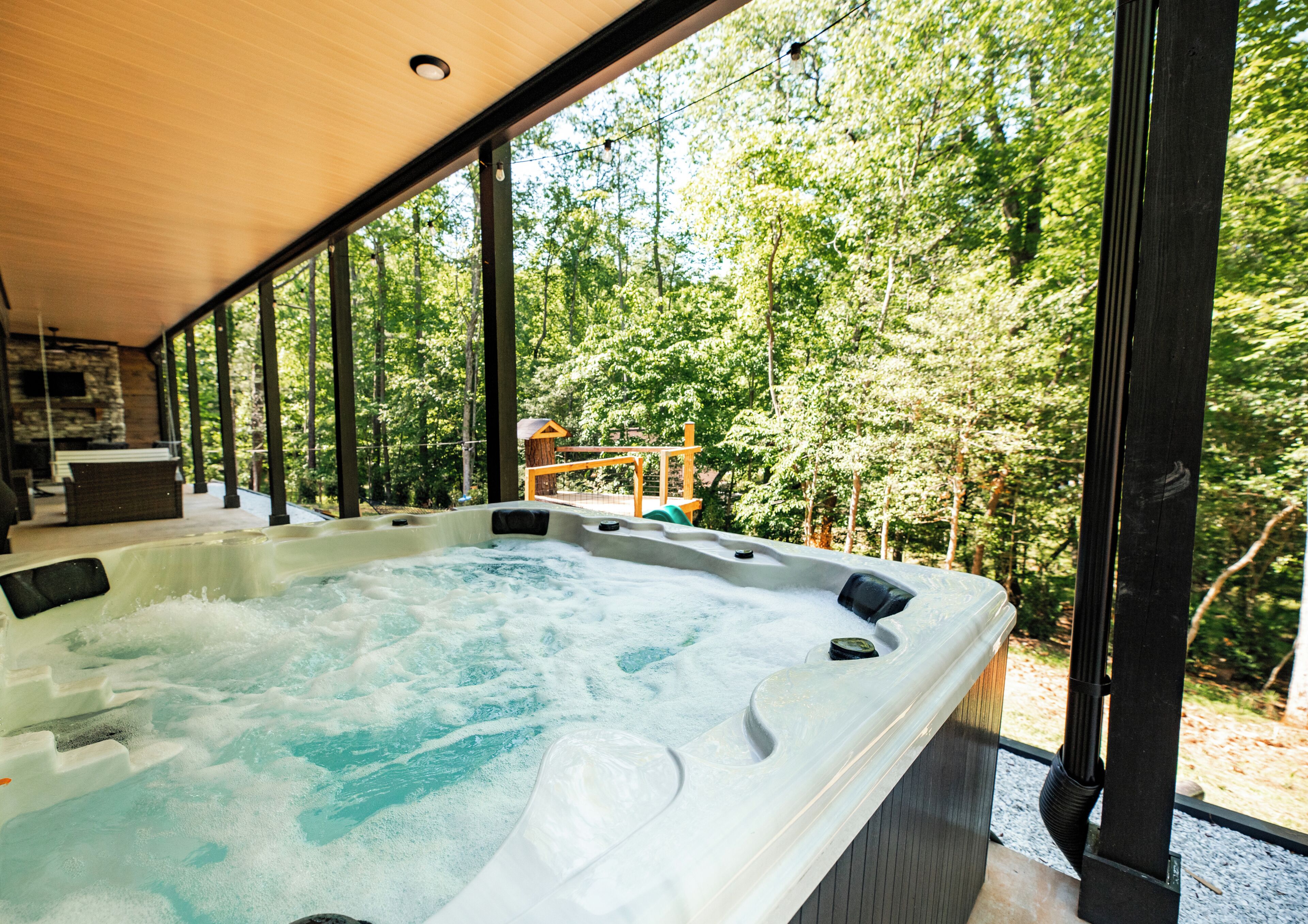 A hot tub with a view of a forested area.