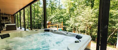 A hot tub with a view of a forested area.