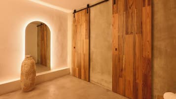 Un pasillo con una puerta corredera de madera, un espejo grande y una lámpara de cerámica con textura.