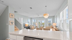 A spacious kitchen with a large island, white cabinetry, and a modern chandelier. - Toes In The Water on 30a!  4-bed directly on 30a!  Steps to pool and beach. (Panama City Beach)