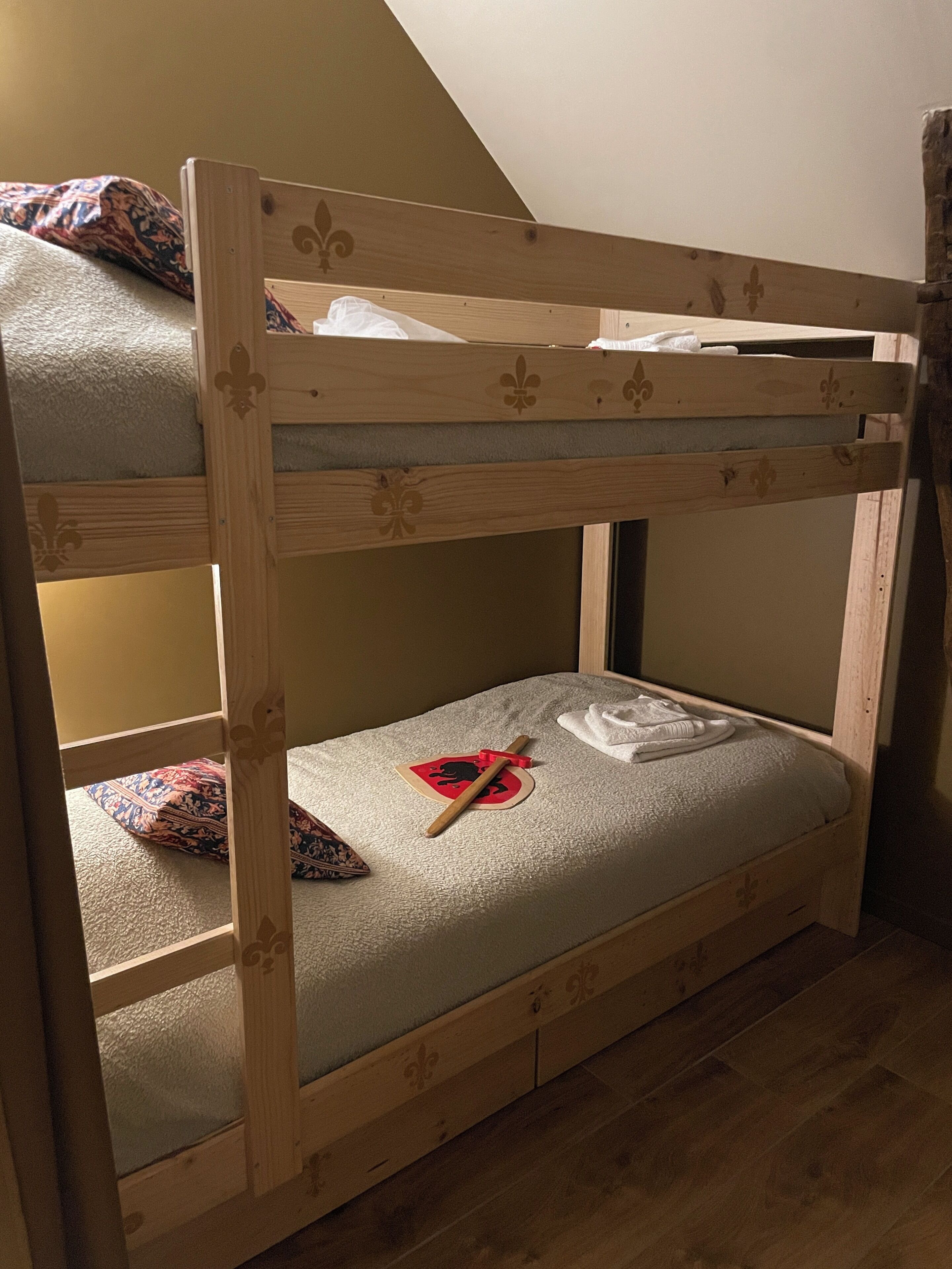 Un lit superposé avec une structure en bois et un matelas.