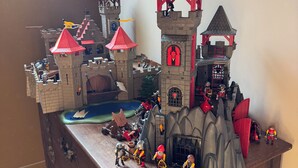 A detailed LEGO castle model with multiple towers and a moat, placed on a wooden dresser. - Unusual: The Knights' Lodge—Medieval-themed, air-conditioned, and featuring balneotherapy (Sens)