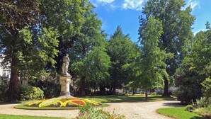 A park with a central statue, surrounded by well-maintained flower beds and trees. - Unusual: The Knights' Lodge—Medieval-themed, air-conditioned, and featuring balneotherapy (Sens)