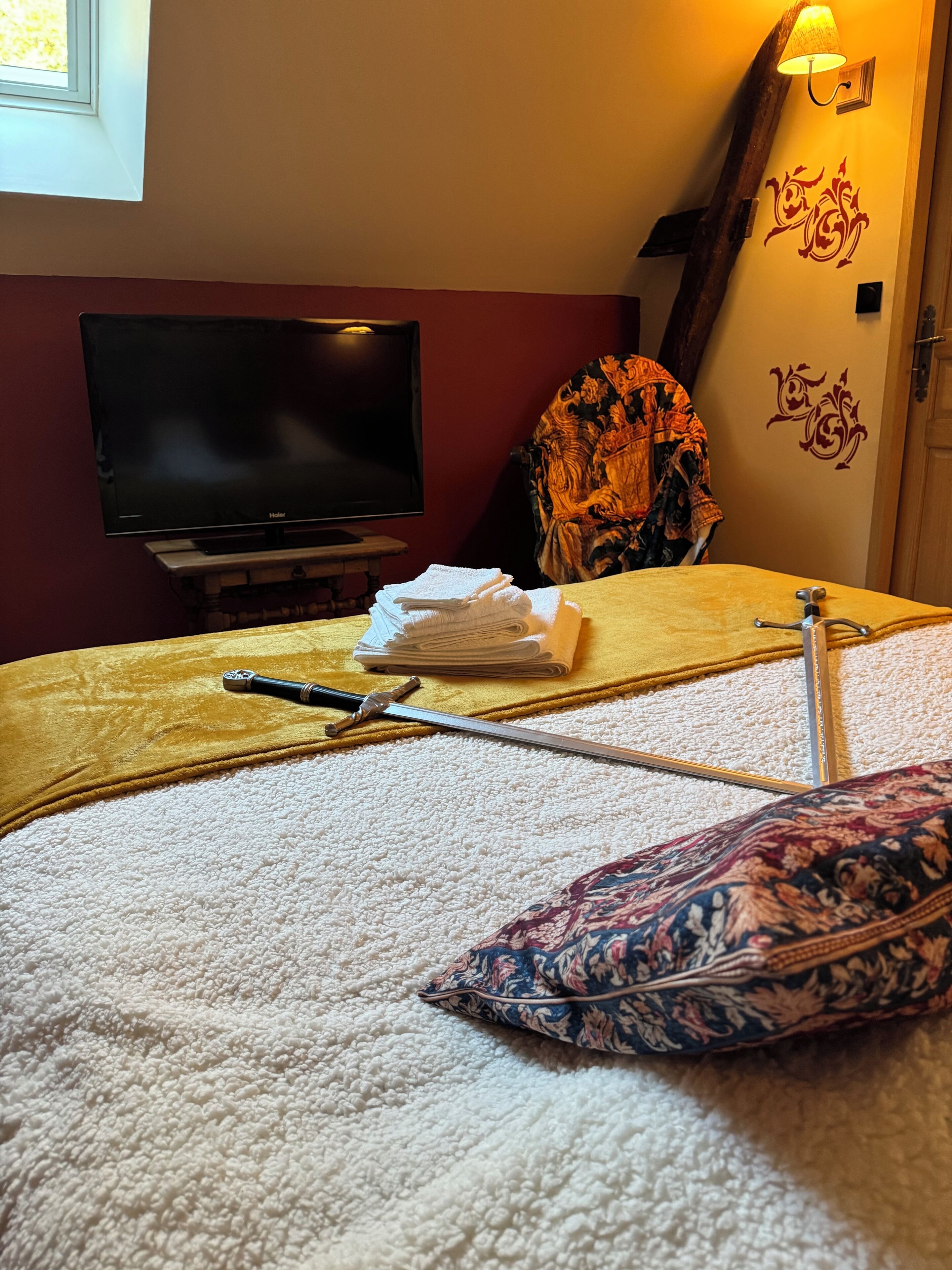 Une chambre d’hôtel avec un lit, une télévision, une lampe et un mur décoratif.