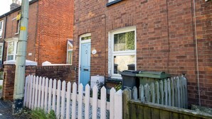 A row of terraced houses with brick facades, a white picket fence, and a blue door. - Pass the Keys | Townhouse in Rye, East Sussex, near Camber Sands (Rye)