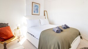 A neatly arranged bedroom with a bed, pillows, a lamp, and a framed picture on the wall. - Pass the Keys | Townhouse in Rye, East Sussex, near Camber Sands (Rye)