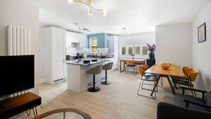 Un appartamento moderno con cucina, zona pranzo e soggiorno.
