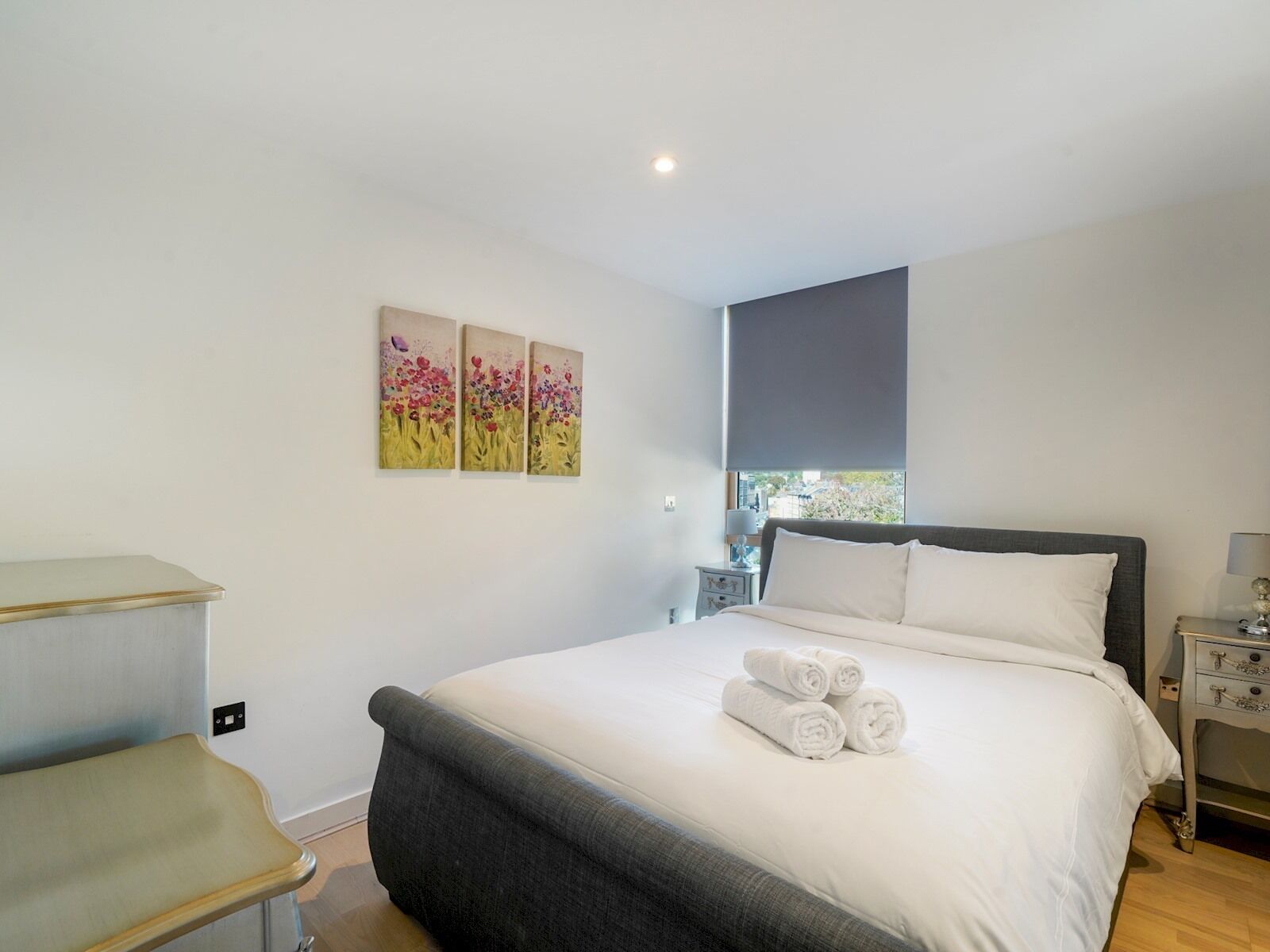 Une chambre à coucher avec un lit, une table de chevet et une fenêtre.