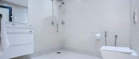 Un baño moderno con ducha, inodoro y lavamanos.
