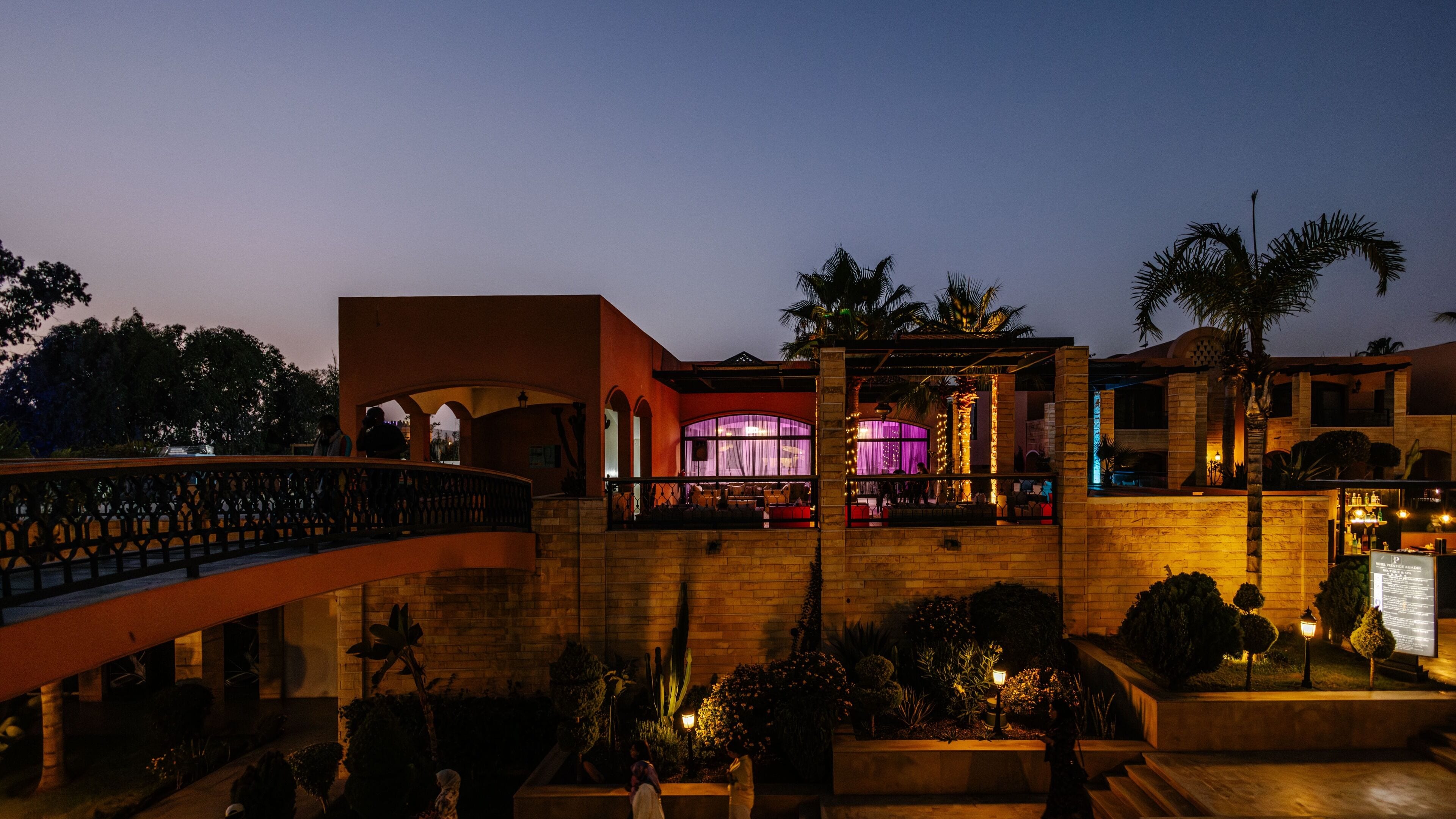 A hotel with a central courtyard, a covered outdoor seating area, and a bar.