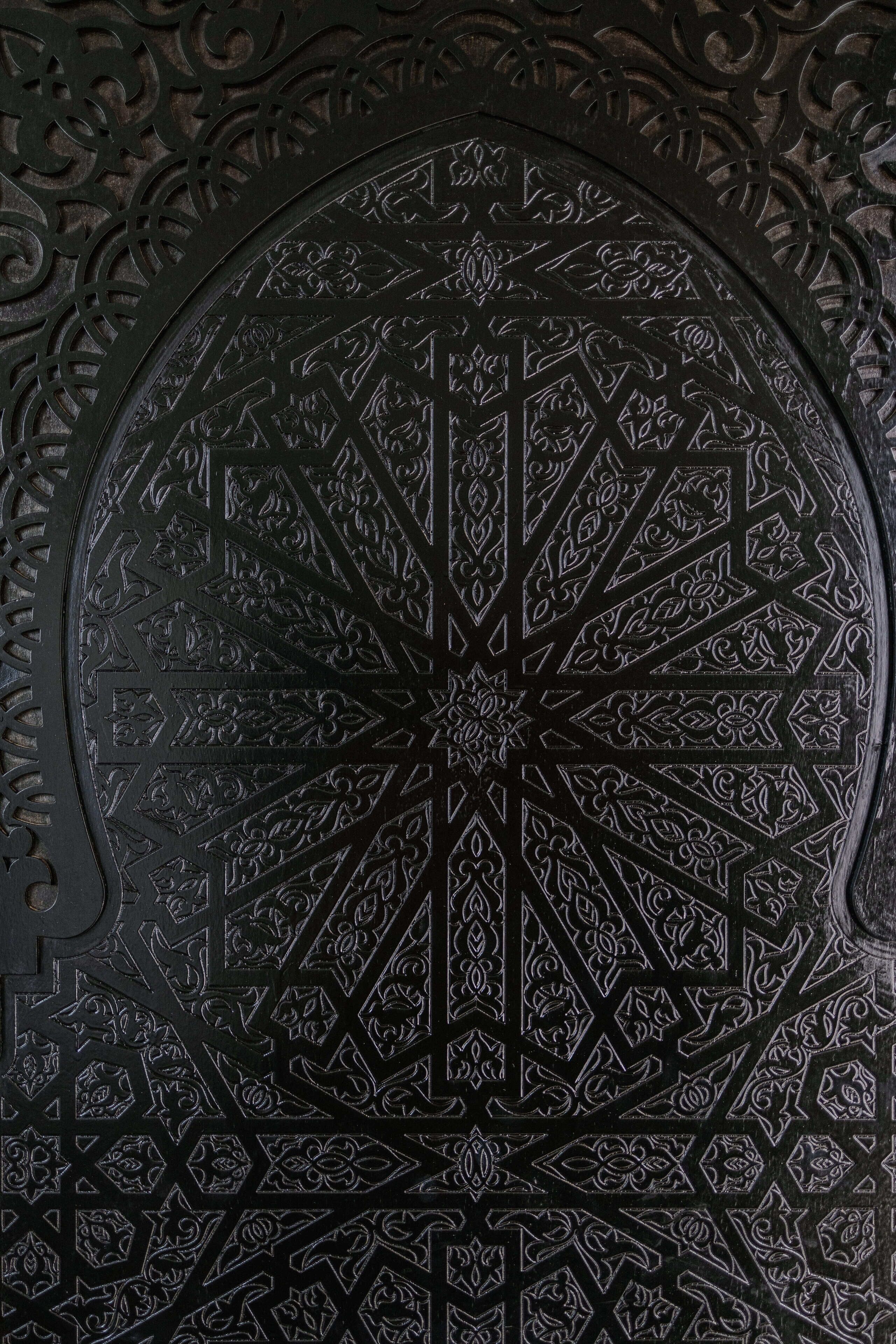 Una puerta metálica circular detallada con intrincados diseños geométricos y florales.