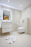 Ein modernes Badezimmer mit Waschbecken, Spiegel und Toilette in Weiß.