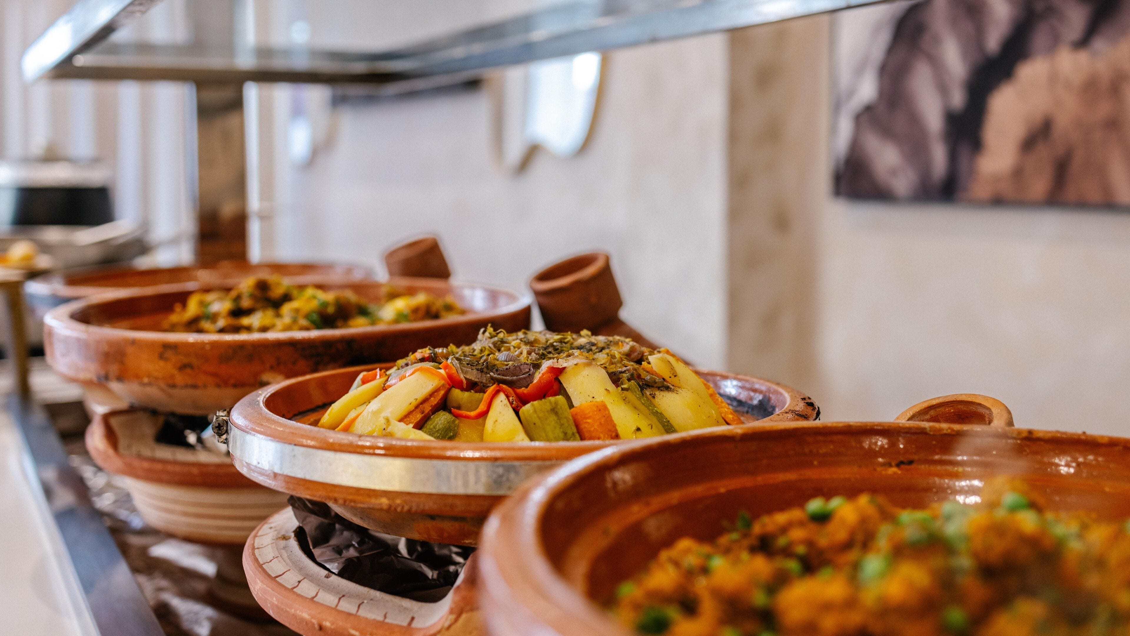 Un buffet proposant divers plats servis dans des récipients traditionnels en argile.