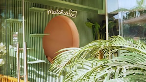 A modern interior with vertical green paneling, a neon sign, and lush green plants. - Hotel Prestige Agadir (Agadir)