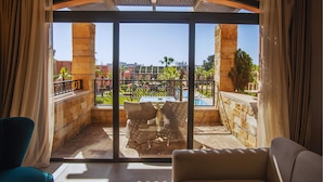 A balcony with a view of a swimming pool, outdoor furniture, and a clear sky. - Hotel Prestige Agadir (Agadir)
